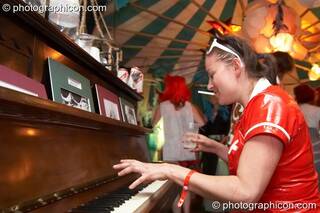 A woman plays the piano in a late night bar at the Secret Garden Party 2008. Huntingdon, Great Britain. © 2008 Photographicon