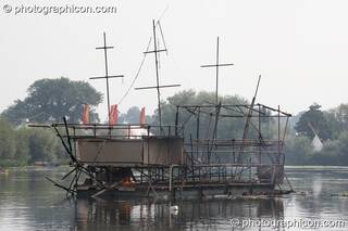 The burned out metal frame of the Galleon ship on the lake at the Secret Garden Party 2008. Huntingdon, Great Britain. © 2008 Photographicon