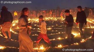 People walk the path through the blazing Green Dragon fire labyrinth at Sunrise Celebration 2007. Yeovil, Great Britain. © 2007 Photographicon