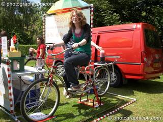 Woman on pedal powered smoothie maker at Kingston Green Fair 2006. Kingston upon Thames, Great Britain. © 2006 Photographicon
