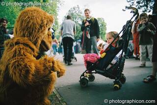 Man in gorilla costume talks to girl in push chair at Kingston Green Fair 2003. Kingston upon Thames, Great Britain. © 2003 Photographicon