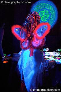 Girl dressed in winged angel outfit under UV light in the Liquid Connective space at the Synergy Project. London, Great Britain. © 2005 Photographicon