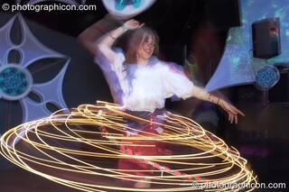 A woman spins an illuminated Hula Hoop leaving a skirt-shaped light trail  in the Liquid Records room at Luminopolis (formerly The Synergy Project). London, Great Britain. © 2008 Photographicon
