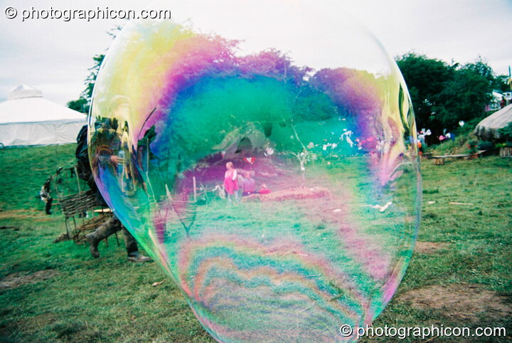 Iridescent reflections in a giant bubble at Big Green Gathering 2003. Cheddar, Great Britain. © 2003 Photographicon