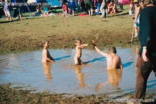 Kids wading in a mud lake at Big Green Gathering 2003. Cheddar, Great Britain. © 2003 Photographicon