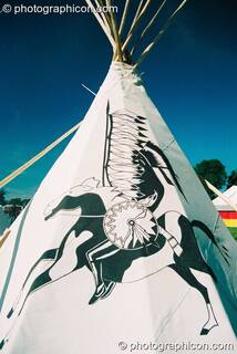 Apache warrior motif on the side of a tipi against deep blue sky at Big Green Gathering 2003. Cheddar, Great Britain. © 2003 Photographicon