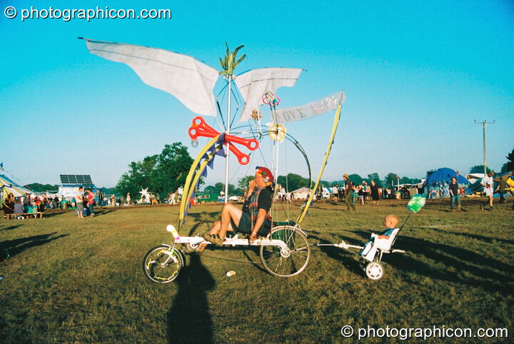 Professor Des Kay takes his son for a ride in his bicycle-drawn chariot at Big Green Gathering 2003. Cheddar, Great Britain. © 2003 Photographicon