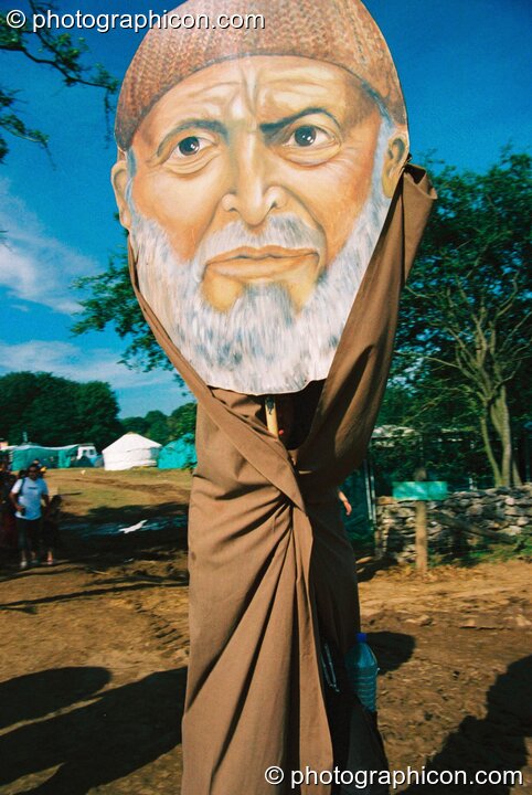 Person in a robe with a very large cardboard head mask at Big Green Gathering 2003. Cheddar, Great Britain. © 2003 Photographicon