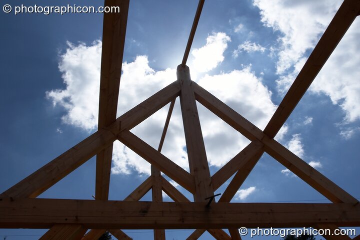 Fluffy cloud in blue sky as seen through a timber 'A-frame' at Big Green Gathering 2005. Burrington, Cheddar, Great Britain. © 2005 Photographicon