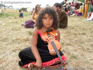 A girl plays the violin on the grass at Big Green Gathering 2006. Burrington, Cheddar, Great Britain. © 2006 Photographicon