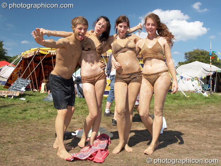 Four muddy youths dressed for sunbathing link arms at Big Green Gathering 2007. Burrington, Cheddar, Great Britain. © 2007 Photographicon