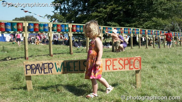 A young girl respects the Tibetan Buddhist prayer wheels in the Healing Field at Big Green Gathering 2007. Burrington, Cheddar, Great Britain. © 2007 Photographicon