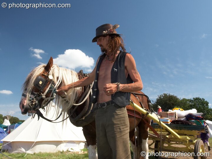 A man holds his horse after a hot day pulling luggage in a cart at Big Green Gathering 2007. Burrington, Cheddar, Great Britain. © 2007 Photographicon