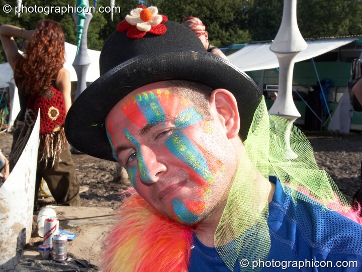 A man wearing a painted face and hat gives a sideways look at Glade Festival 2007. Aldermaston, Great Britain. © 2007 Photographicon