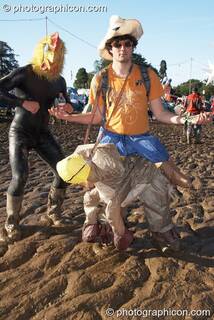 A man wearing a rubber chicken suit dances in the mud with his friend wearing a plastic sheep at Glade Festival 2007. Aldermaston, Great Britain. © 2007 Photographicon