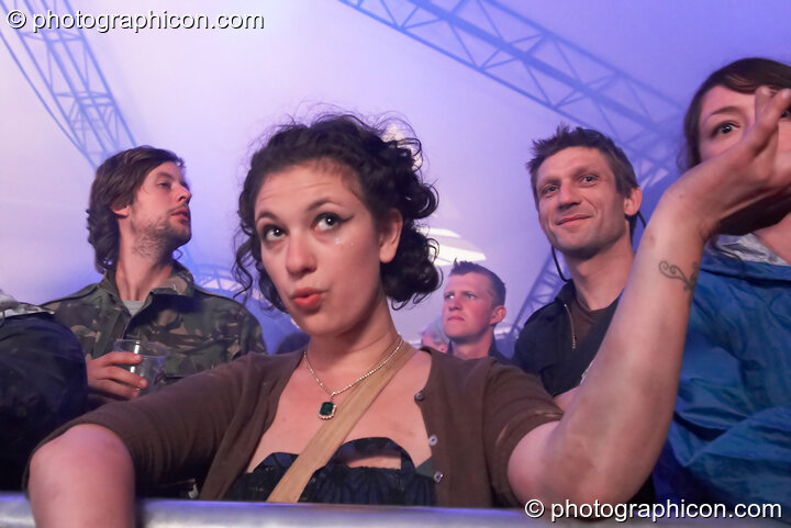 A woman shrugs framing the glances of others in the audience of the Glade Stage at Glade Festival 2007. Aldermaston, Great Britain. © 2007 Photographicon