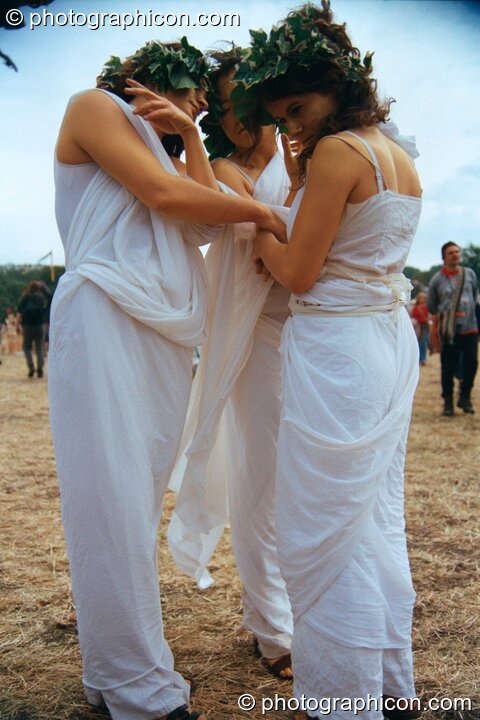 Three women dressed as though in ancient Greece perform a theatrical dance at Glastonbury Festival 2002. Pilton, Great Britain. © 2002 Photographicon