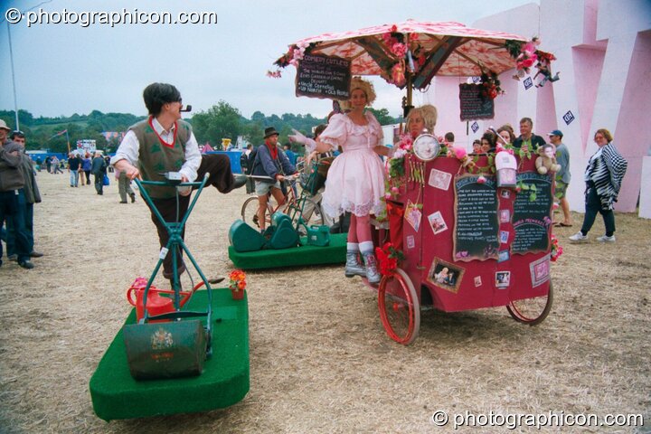 A team of circus gardeners on self-propelled strips of grass at Glastonbury Festival 2002. Pilton, Great Britain. © 2002 Photographicon