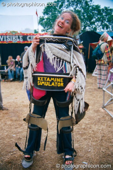 A woman wearing the leg-braces of a Ketamine Simulator in the Lost Vaguess field at Glastonbury Festival 2002. Pilton, Great Britain. © 2002 Photographicon