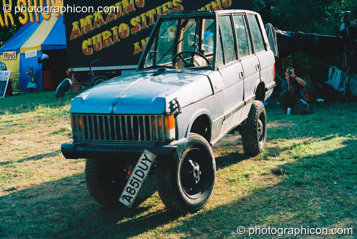 An extra thin Range Rover in the Lost Vagueness field at Glastonbury Festival 2003. Pilton, Great Britain. © 2003 Photographicon
