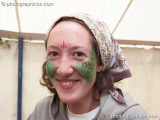 Portrait of a Green Police officer as they prepare their costume, with face painting by Simone &amp; Natalie Kay, at Glastonbury Festival 2007. Pilton, United Kingdom. © 2007 Photographicon