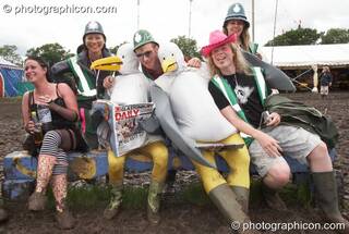 The Green Police pose with people in duck costume sitting on a bench at Glastonbury Festival 2007. Pilton, United Kingdom. © 2007 Photographicon