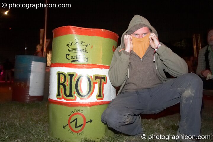 Dodgy Dave squats next to a rubbish bin painted as a Carlsberg Riot beer can at Glastonbury Festival 2008. Pilton, Great Britain. © 2008 Photographicon