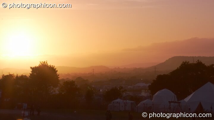 The sun sets over the Glastonbury Festival 2008 as observed from the south west part of the site. Pilton, Great Britain. © 2008 Photographicon