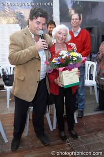 Robin Wood presents Barbara Marx Hubbard with flowers at the Renaissance2 Great Shift Gathering 2009. Perpignan, France. © 2009 Photographicon