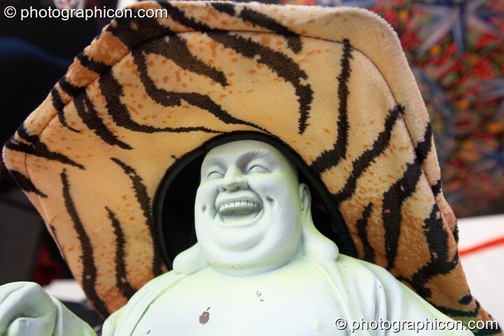 A plastic Buddha decorated with fluro flowers and hat on the Main Stage at Planet Bob's Offworld Festival 2007. Swindon, Great Britain. © 2007 Photographicon