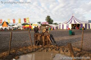 A group of friends jam on a wonky piano next to a pond in the early morning mud at the Secret Garden Party 2007. Huntingdon, Great Britain. © 2007 Photographicon