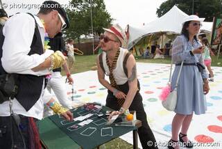 A man plays cards on a small table at the Secret Garden Party 2008. Huntingdon, Great Britain. © 2008 Photographicon