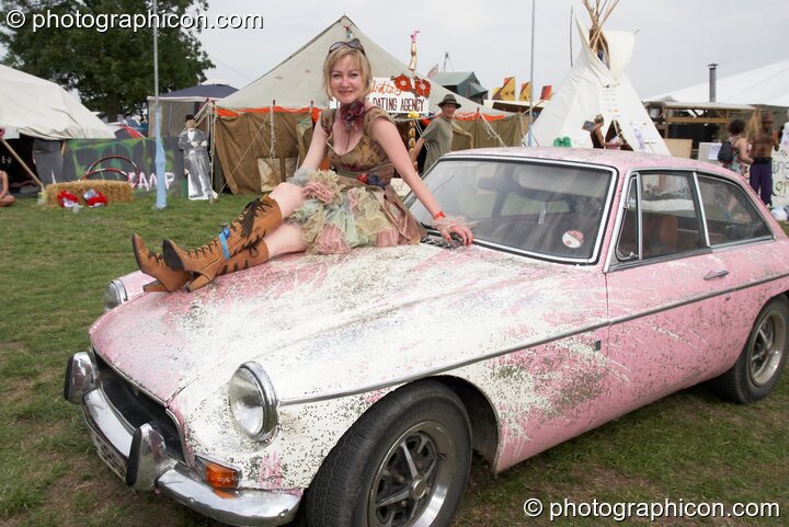 A woman sits on a painted car at the Secret Garden Party 2008. Huntingdon, Great Britain. © 2008 Photographicon
