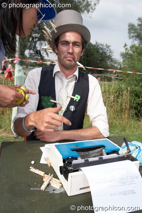 A man in a top hat sits in front of a typewriter at the Secret Garden Party 2008. Huntingdon, Great Britain. © 2008 Photographicon