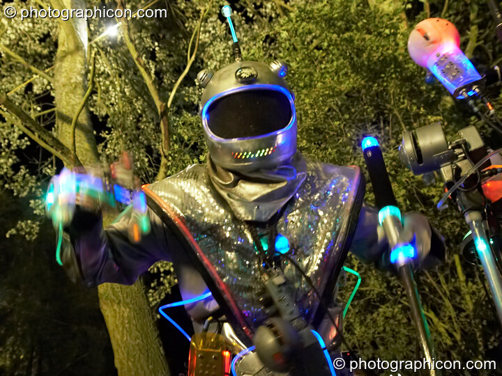 A man in funky space suit makes music by the lake at the Secret Garden Party 2010. Huntingdon, Great Britain. © 2010 Photographicon