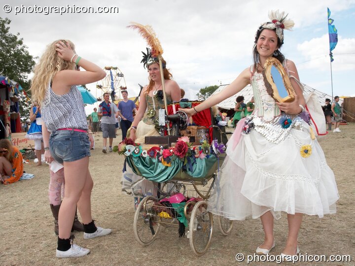 Two women show with pride their pram-bound Singer sewing machine at the Secret Garden Party 2010. Huntingdon, Great Britain. © 2010 Photographicon