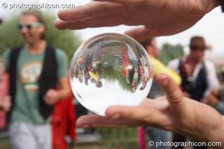 A smal crowd viewed through a clear plastic contact ball at the Secret Garden Party 2010. Huntingdon, Great Britain. © 2010 Photographicon