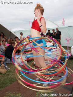 A scantily dressed woman spins multiple hoola hoops at the Secret Garden Party 2010. Huntingdon, Great Britain. © 2010 Photographicon