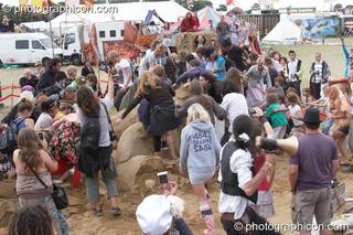 A crowd stomp to death a large sand sculpture by Dirty Beach at the end of the Secret Garden Party 2010. Huntingdon, Great Britain. © 2010 Photographicon