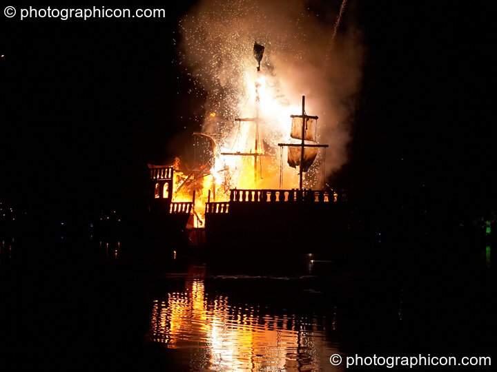 Fireworks erupt aboard the burning Galleon ship on the lake at the Secret Garden Party 2008. Huntingdon, Great Britain. © 2008 Photographicon