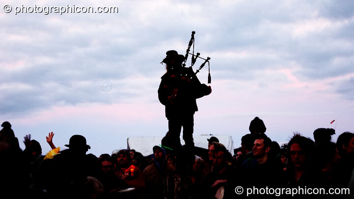 Standing on the Woodhenge, a piper calls the sun to rise for summer solstice at Sunrise Celebration 2006. Yeovil, Great Britain. © 2006 Photographicon