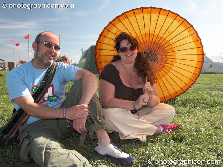 A man a woman sit with a parasol at Sunrise Celebration 2007. Yeovil, Great Britain. © 2007 Photographicon