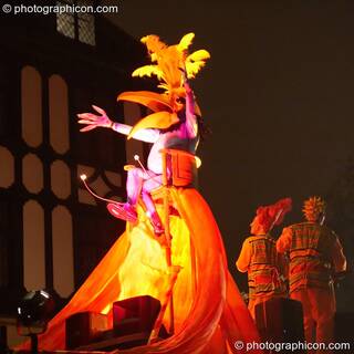 Person in big bird costume bathed in coloured light stips on top of Mandinga Arts' carnival float at the Thames Festival 2005. London, Great Britain. © 2005 Photographicon