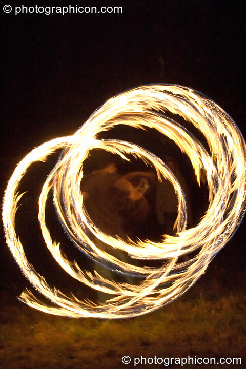 Fire sticks photographed at slow shutter speed to produce motion trails at the Turaya Gathering 2004. Wimborne, Great Britain. © 2004 Photographicon