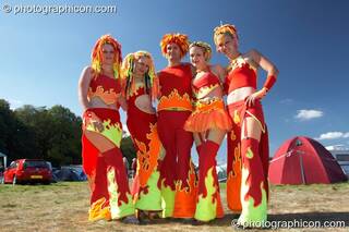 A walkabout troupe all wearing the same colour red and yellow outfits at Waveform Project 2007. Kenton, Exeter, Great Britain. © 2007 Photographicon