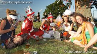 A man and woman dressed as the King and Queen of Hearts have a tea party on the grass at Waveform Project 2007. Kenton, Exeter, Great Britain. © 2007 Photographicon