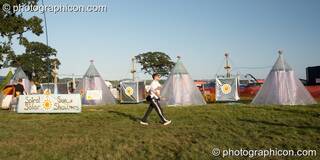 A man walks past the solar showers at Waveform Project 2007. Kenton, Exeter, Great Britain. © 2007 Photographicon