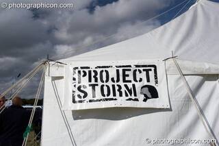 A sign on the Monstrosity/Storm tent blows in the wind as ominous clouds gather at Waveform Project 2007. Kenton, Exeter, Great Britain. © 2007 Photographicon
