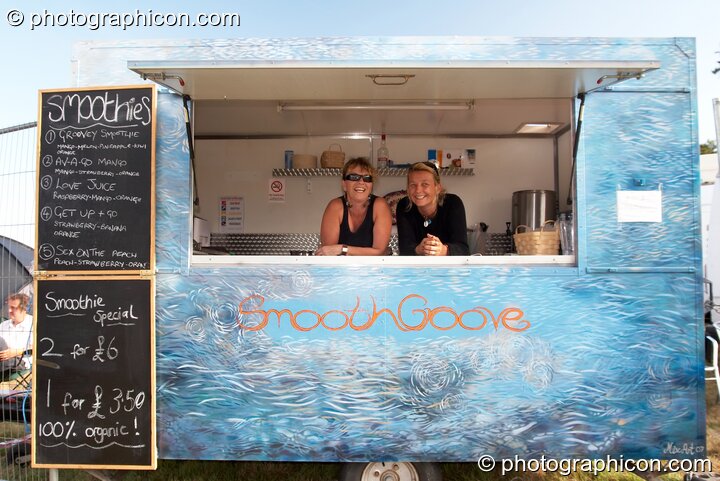 Two women serve inside the Smooth Groove smoothie van at Waveform Project 2007. Kenton, Exeter, Great Britain. © 2007 Photographicon