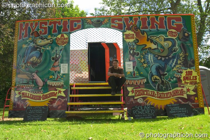 Man sitting on the steps of the Mystic Swing ride at Kingston Green Fair 2004. Kingston Upon Thames, Great Britain. © 2004 Photographicon